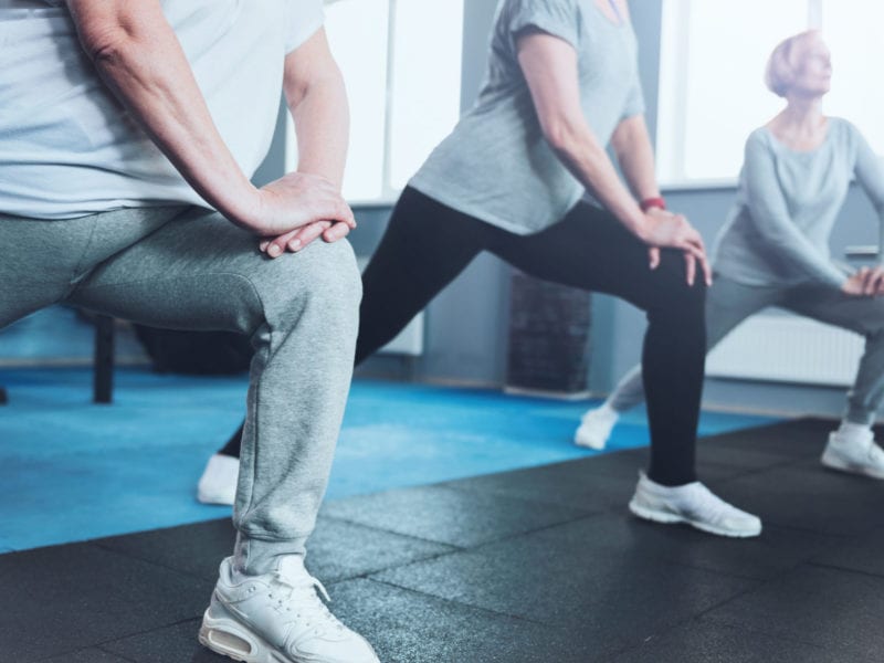 Three people manage joint pain by doing yoga bend at the knee.