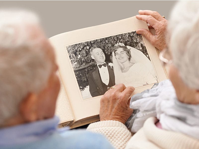 A senior couple looks at their old wedding photos