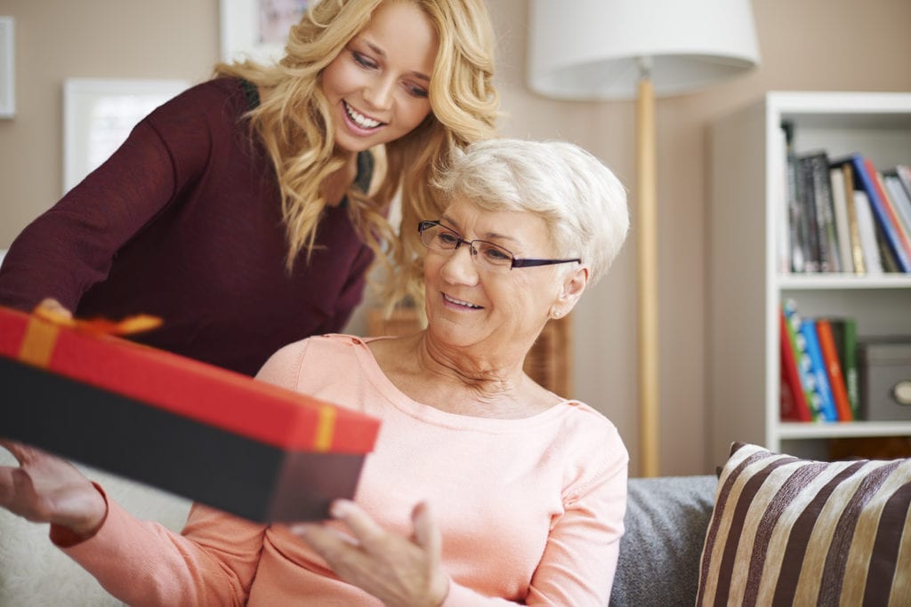 A woman at Culpepper Place receives a present from the list of best gift ideas for elderly women from her granddaughter
